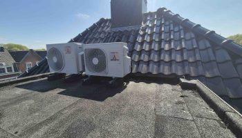 Twee buitendelen van de airco geplaatst op een dakkapel van een vrijstaand huis.
